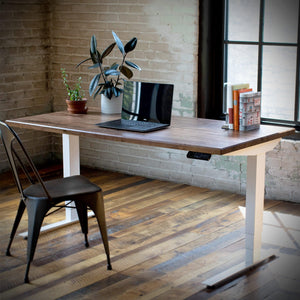 Hardwood slab desk displayed in workspace on electric adjustable base